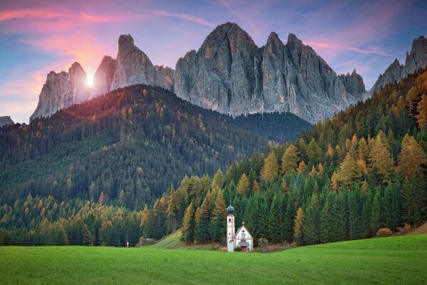 Temple sur fond de coucher de soleil dans les montagnes alpines