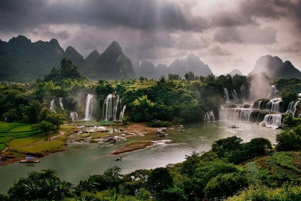 Paysage avec un plan d eau et des cascades sous les rayons du soleil à travers les nuages