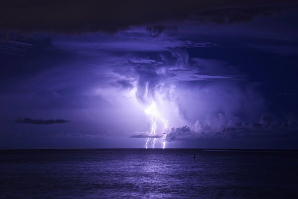 Night storm with thunderstorm and lightning over the sea