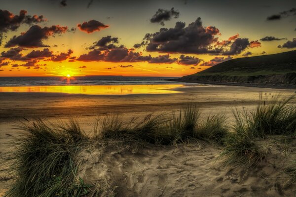 Der Sandstrand ist von der untergehenden Sonne beleuchtet