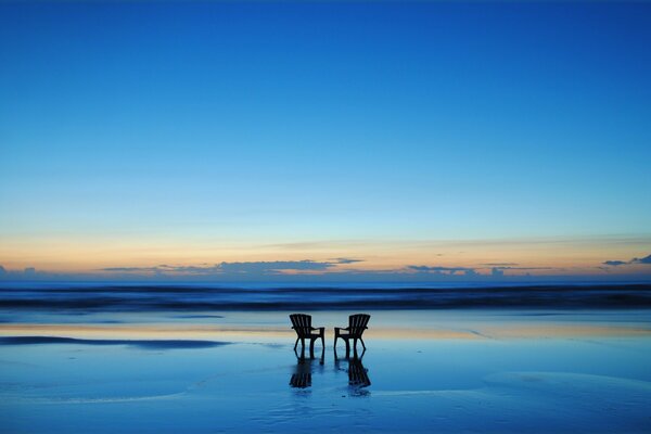 Chairs on the background of the river and the sky