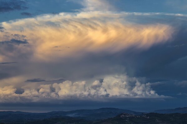 Paisaje colinas pueblo nubes