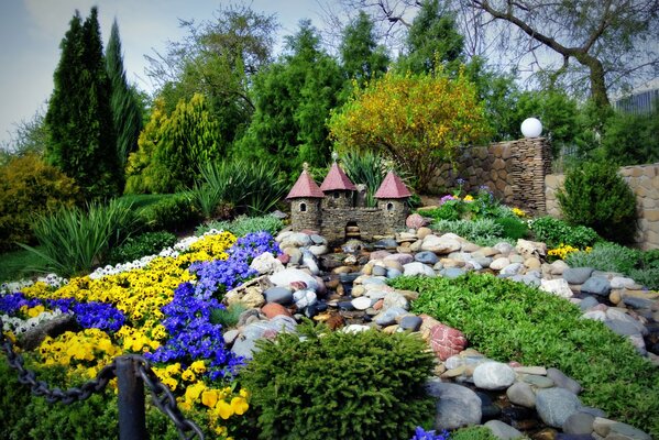 Un pequeño castillo en medio de piedras y flores