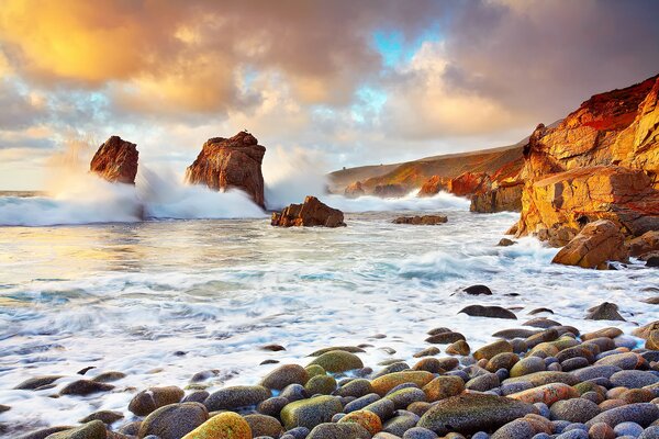 At the shore of the waves at sunset