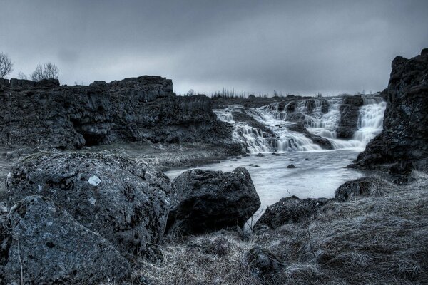 Dark landscape. Waterfall in the rocks