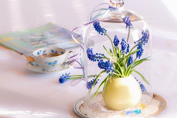 Eine Tasse Tee und ein Blumenstrauß in einem Glaskolben