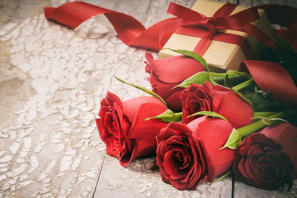 A gift and a bouquet of red roses