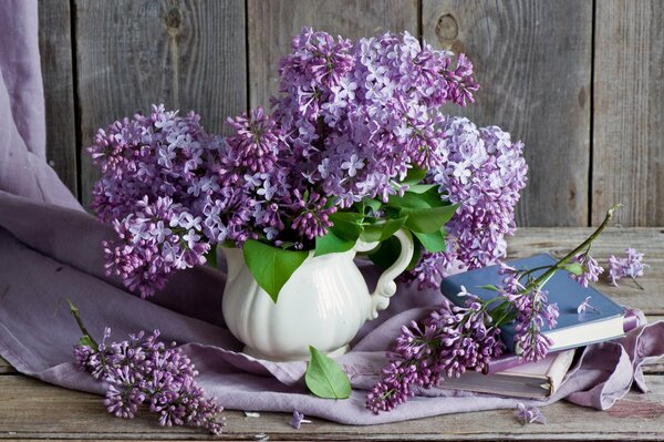 Natura morta con un bouquet di lillà e un libro