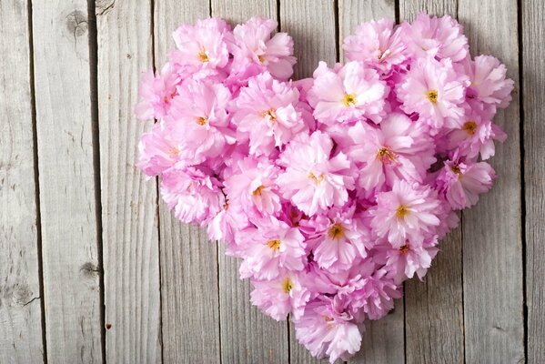 Cuore di fiori su sfondo di legno