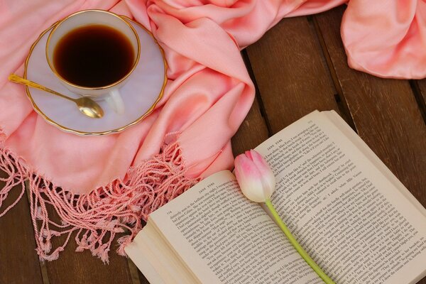 A book with a tulip over a cup of coffee