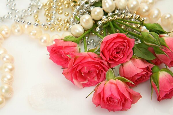 Collier de perles sur un bouquet de roses