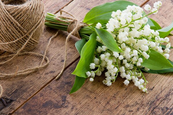 A bouquet of lilies of the valley wrapped with a rope