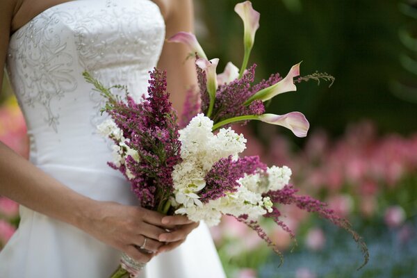 The bride holds a bouquet of flowers in her hands