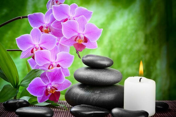 Thai massage with stones with a candle and flowers