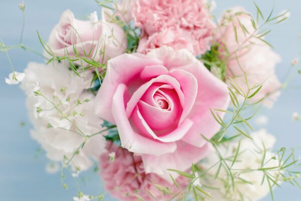 Blumenstrauß aus rosa und weißen Blumen auf blauem Hintergrund