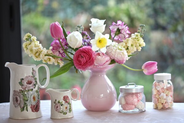 Foto von einem Blumenstrauß in einer Vase aus Tulpen von Rosen und Narzissen