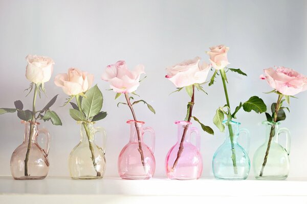 Composition de roses dans des récipients en verre