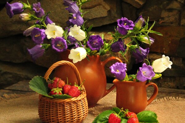 Nature morte bouquet dans un pichet de cloches dans un panier de fraises