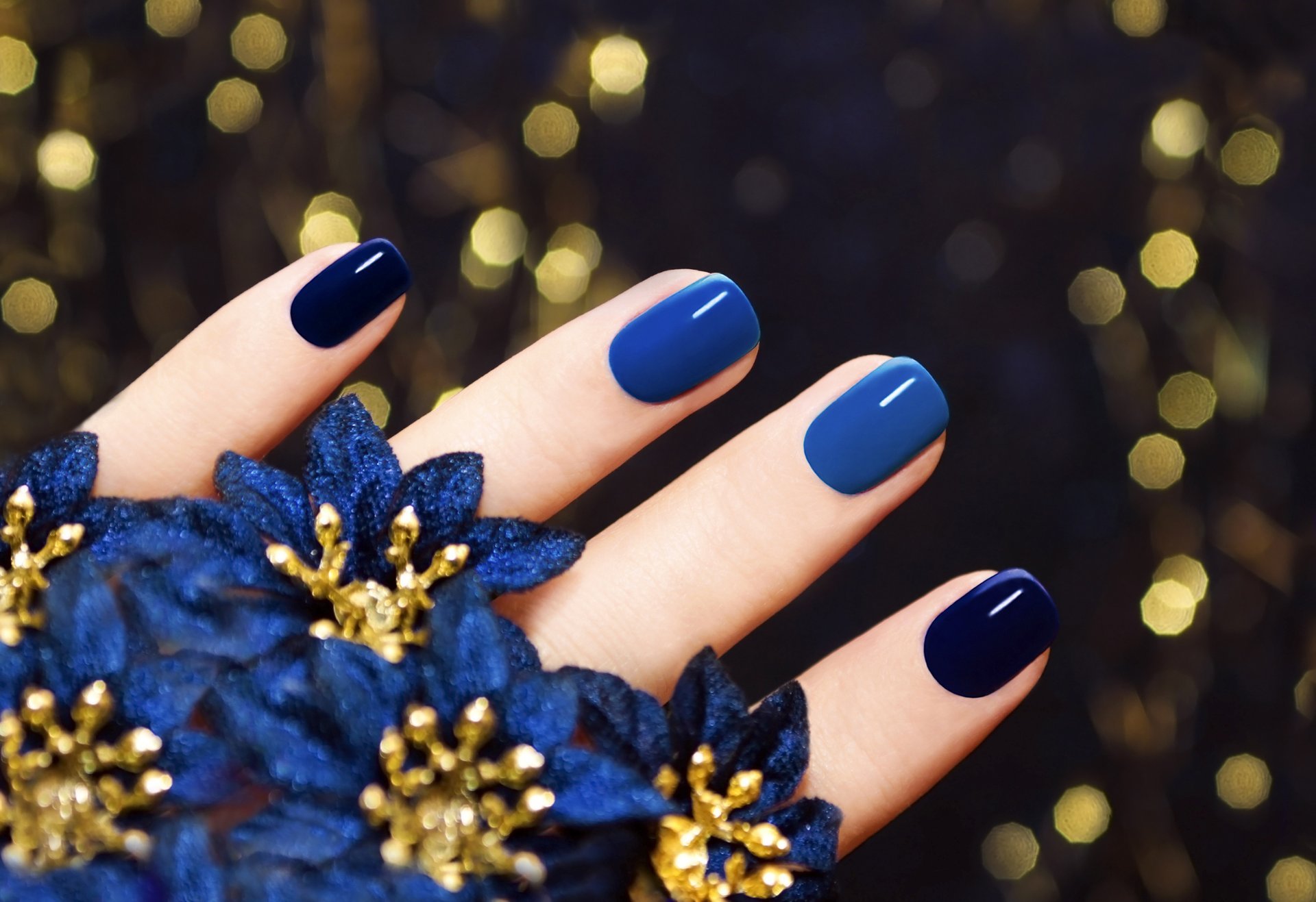 macro dita unghie manicure fiori blu sfondo