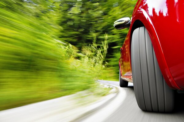 Coche rojo a la velocidad en una curva