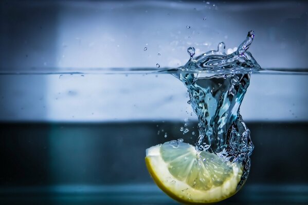 Una fetta di limone che cade nell acqua