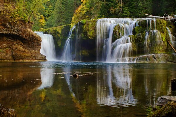 Landschaft eines Wasserfalls, der im Wald in einen See mündet