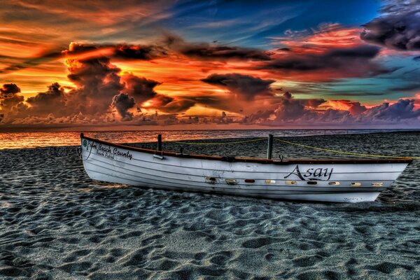 Barco en la playa y puesta de sol