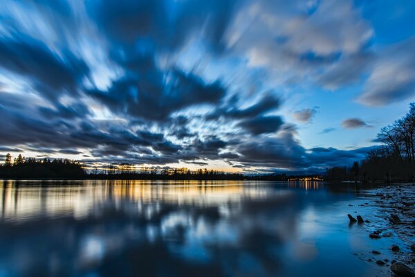 Lake shore at sunset with clouds