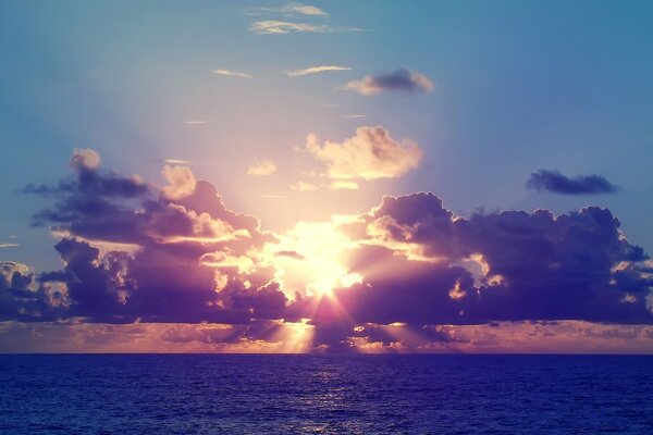 Puesta de sol en el mar rayos en el cielo