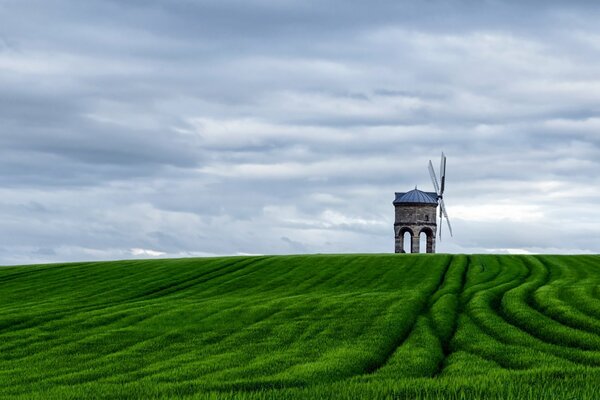 Mühle im Feld vor dem Hintergrund der Wolken