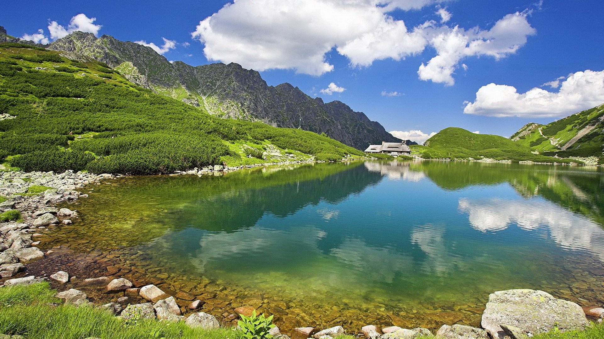 naturaleza verano cielo montañas lago transparente agua en lejos cabaña