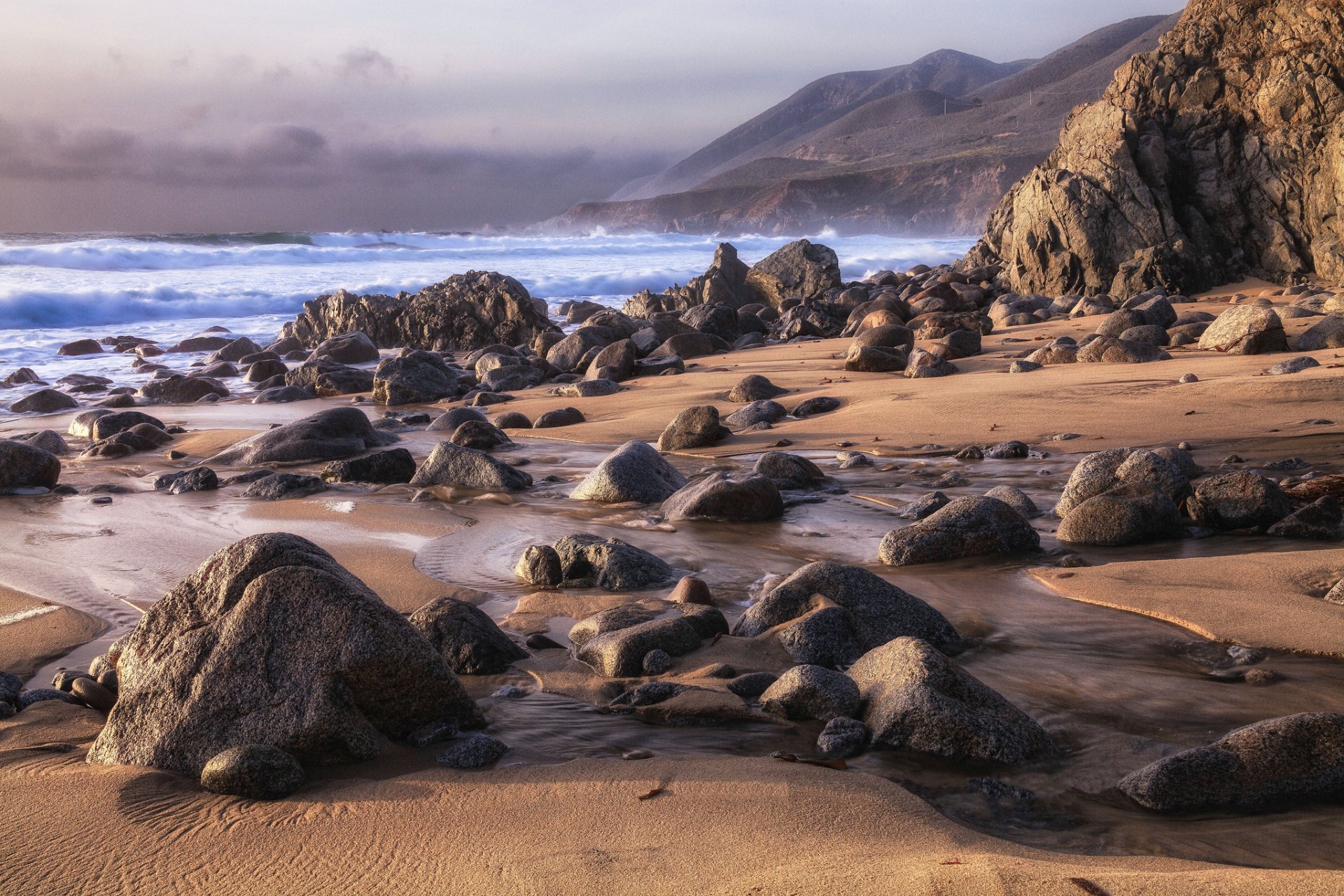 beach sand rocks shore rocks waves sea sky