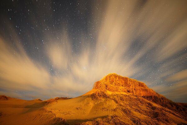 Clouds are rushing over the dunes, hiding the starry not about