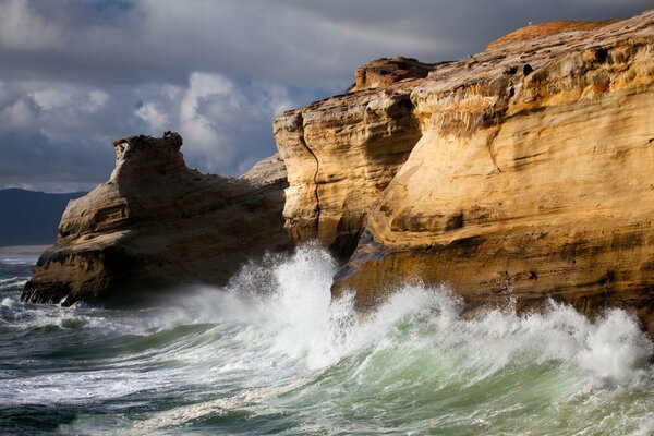 Schäumende Meereswellen, die gegen die Klippen der Klippe schlagen