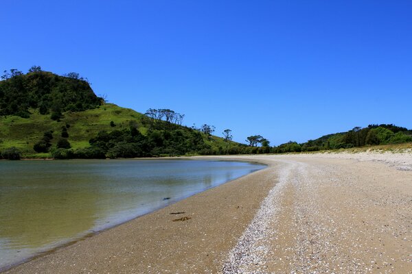 Plage de sable du lac près des collines