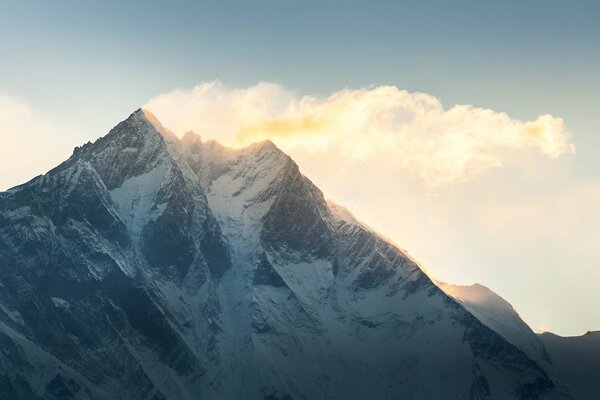 Verschneite Bergspitze auf Himmelshintergrund mit Wolken