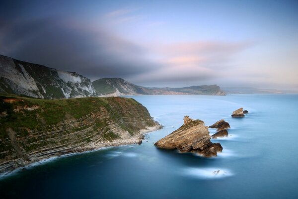 Rocks in the sea against a haze at dusk