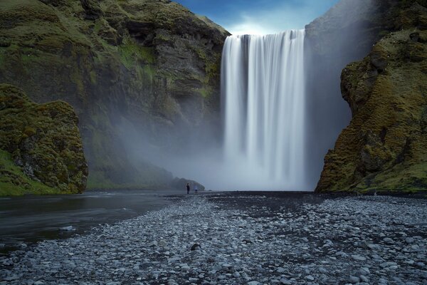 Glatter weißer Wasserfall unter den Felsen