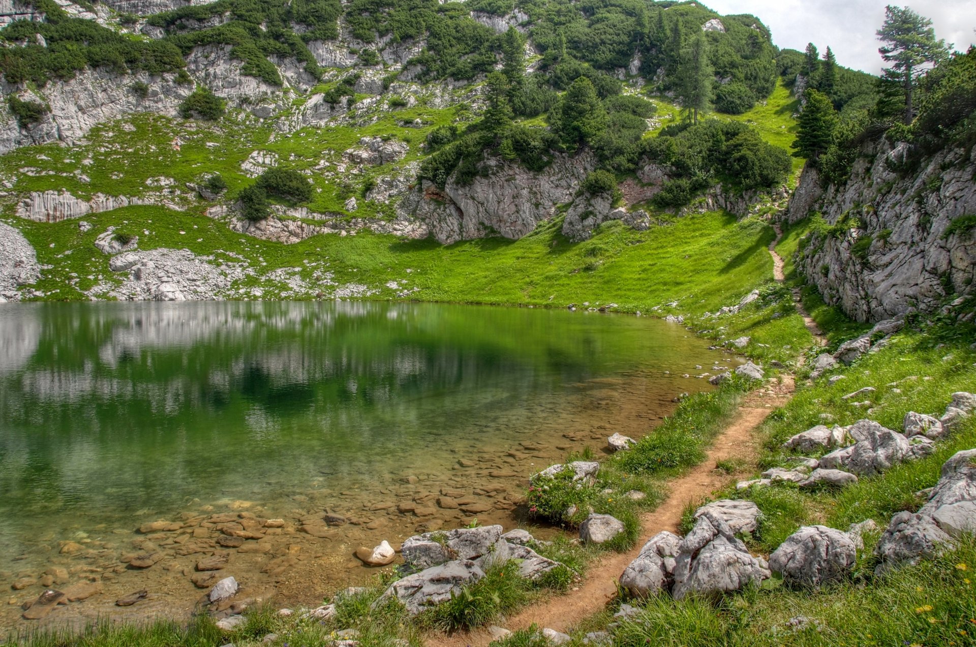 lac montagnes verdure herbe pierres collines sentier surface réflexion