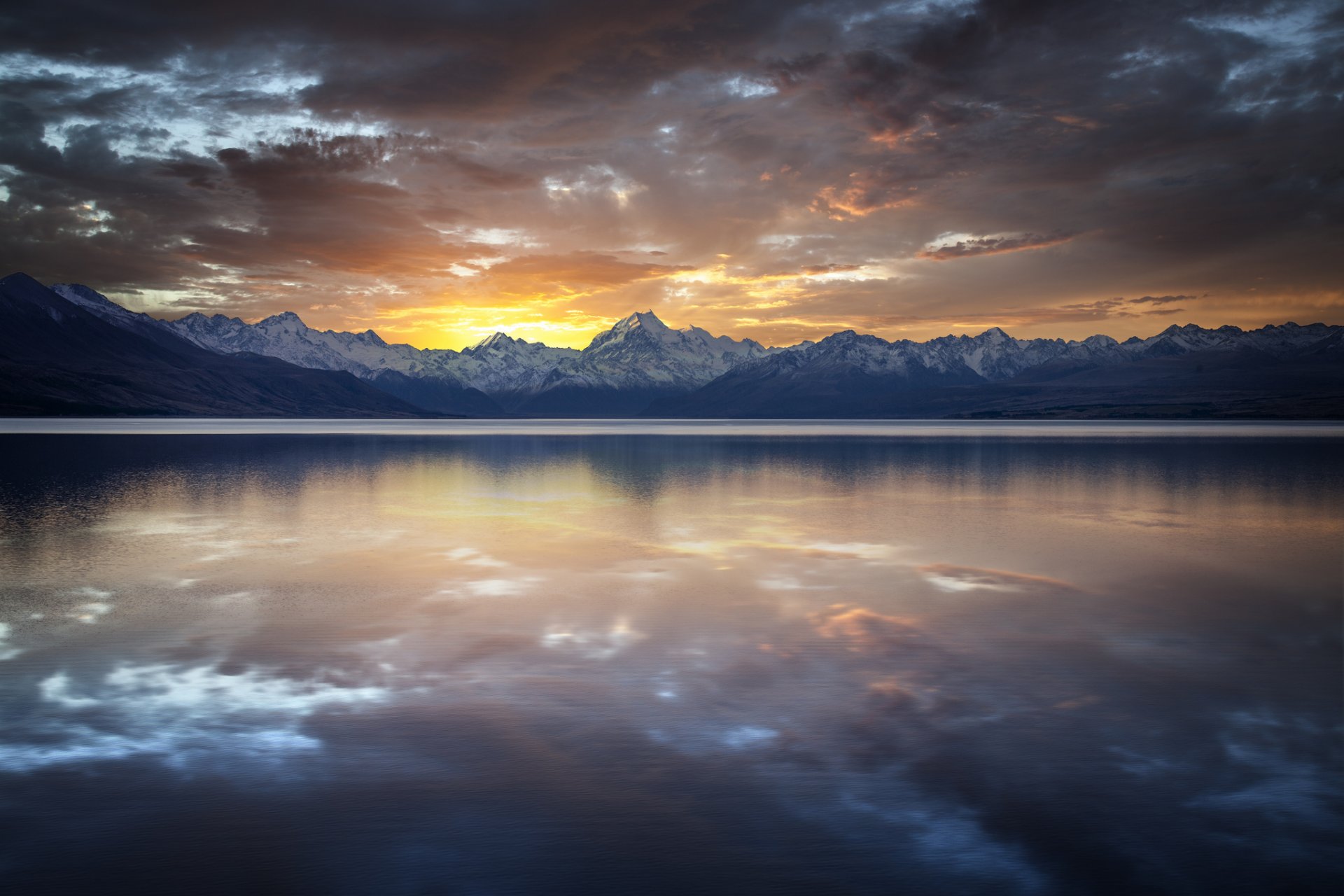 lac montagnes roches crête surface réflexion coucher de soleil nuages