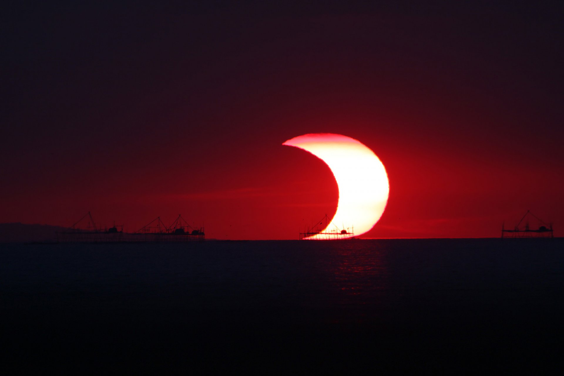 soleil lune éclipse partielle océan horizon