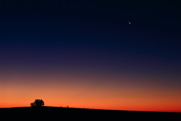 Roter Sonnenuntergang. Mond am Nachthimmel