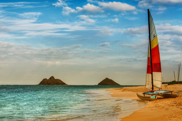 Sailing catamaran on the beach by the sea