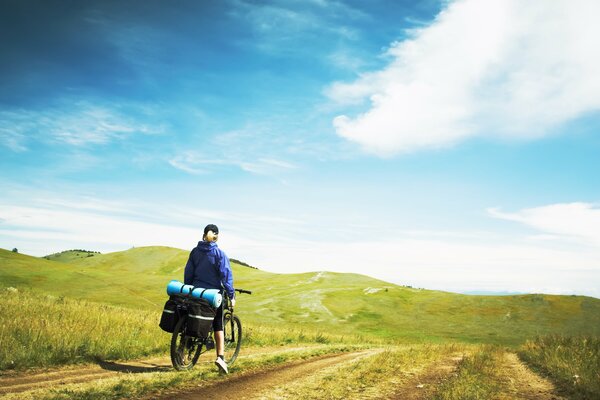 Ragazza che viaggia in bicicletta tra le colline