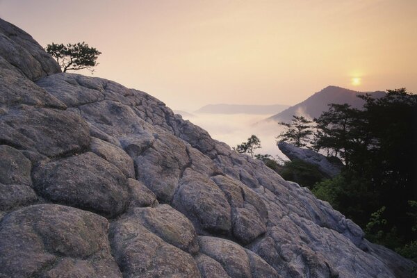 Puesta de sol en las montañas en lo alto de la roca