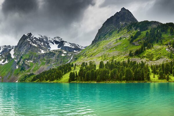 Ein klarer blauer See inmitten verschneiter Berge