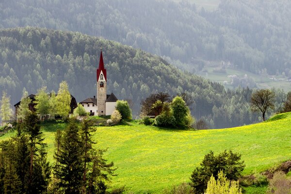 Eine Kapelle in den Bergen. Grüne Wiese