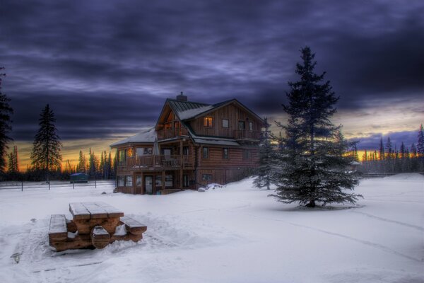 Maison en bois dans la neige en hiver