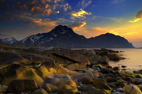 Steep stone shore against the backdrop of high mountains