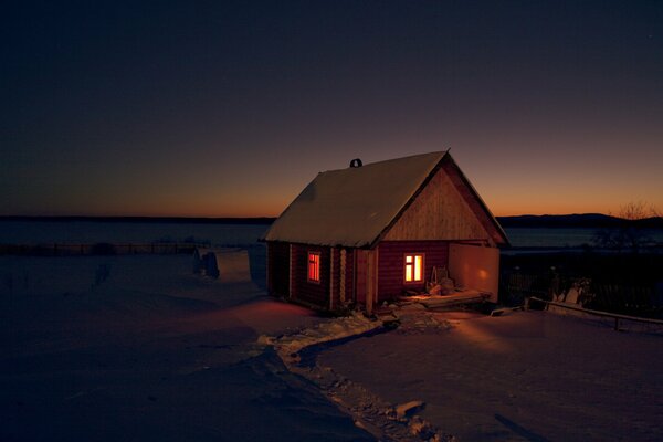 A house with glowing windows in the steppe